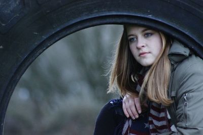 Close-up of angry woman seen through tire