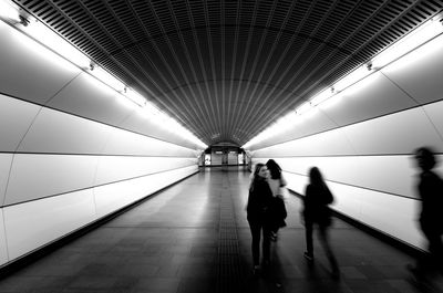 People walking in illuminated tunnel