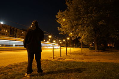 Full length of man standing on illuminated street at night