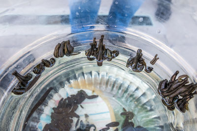 High angle view of reflection of clock on glass