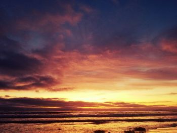 Scenic view of sea against dramatic sky during sunset