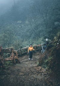 Men standing on log in forest