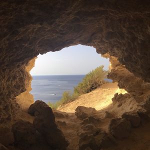 Scenic view of sea seen through cave