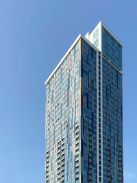 Low angle view of modern building against clear blue sky