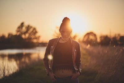 Rear view of woman standing in front of river