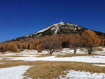 Scenic view of snowcapped mountains against clear blue sky
