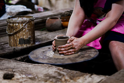 Midsection of woman making pot