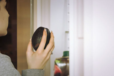 Midsection of woman holding avocado 