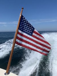 Flag on sea against sky