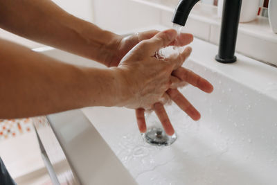 Person wash hands in the bathroom. concept of health and protection.