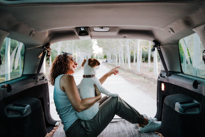 Woman sitting with dog in car