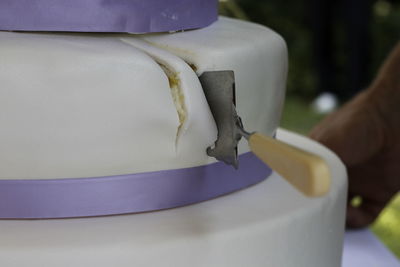 Close-up of wedding cake with server