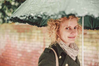 Portrait of smiling woman holding umbrella