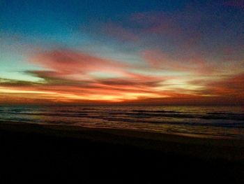 Scenic view of sea against dramatic sky during sunset