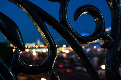 Illuminated city seen through wrought iron