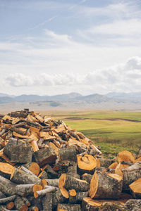 Stack of stones on field against sky