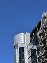 Low angle view of modern building against clear blue sky