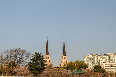 Panoramic view of buildings and trees against sky