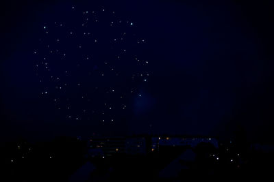 Illuminated cityscape against sky at night