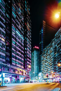 Illuminated buildings by street in city at night