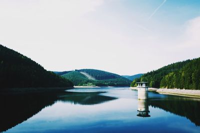 Scenic view of lake in forest against sky