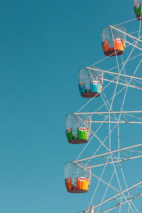 Low angle view of ferris wheel against clear blue sky