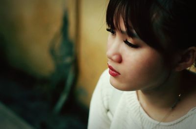 Close-up of thoughtful young woman looking away at home