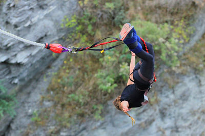 Full length of man hanging on rope