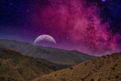 Scenic view of mountains against sky at night