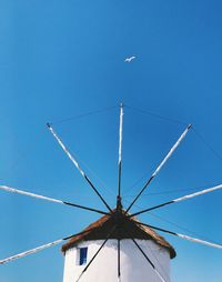 Low angle view of bird flying against clear blue sky