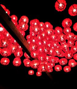 Low angle view of illuminated lanterns hanging at night
