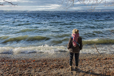 Woman standing at stormy lake starnberg near ambach bavaria