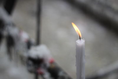 Close-up of burning candles on metal