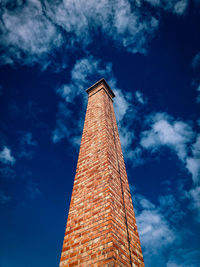 Low angle view of historical chimney against cloudy sky