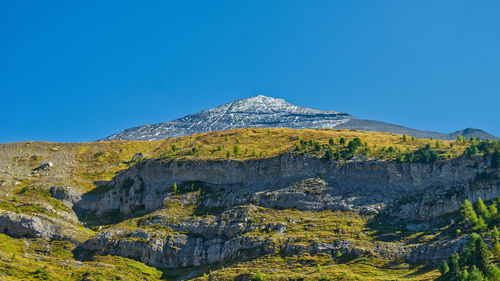 Low angle view of mountain against blue sky