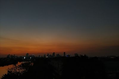 Silhouette buildings against sky during sunset