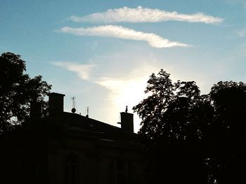 Silhouette trees against cloudy sky