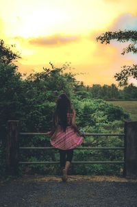 Rear view of girl standing by water