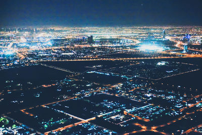 High angle view of illuminated cityscape against sky at night