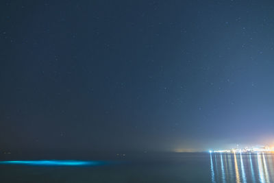 Blue clear sky with stars red sea and light from night divers