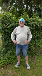 Portrait of man standing against plants