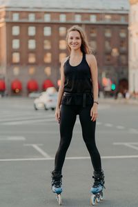 Full length portrait of young woman standing in city