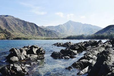 Scenic view of sea and mountains against sky