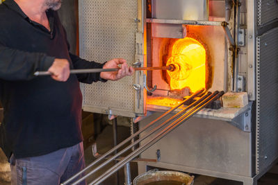 Midsection of man working in factory