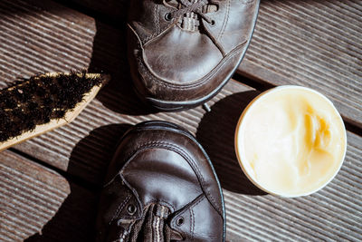 High angle view of shoes with polish and brush on table