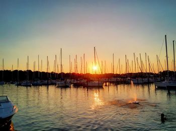 Sailboats in sea at sunset