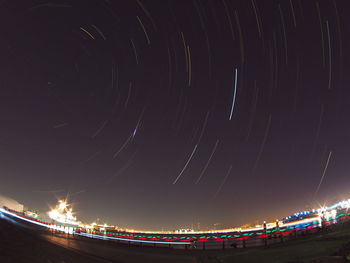 Low angle view of light trails against sky at night