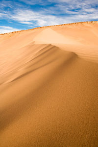 Sand dunes in desert against sky