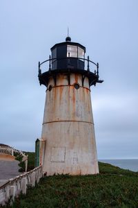 Low angle view of lighthouse by sea against sky