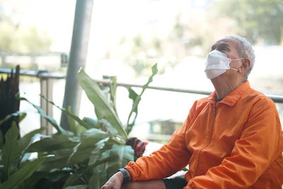 Side view of young woman sitting on field